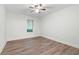 Bedroom with gray wood flooring, window with blinds and a ceiling fan with light fixture at 705 Country Park Se Dr, Smyrna, GA 30080