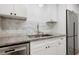 Close-up of kitchen sink and granite counters with stainless steel appliances and marble backsplash at 705 Country Park Se Dr, Smyrna, GA 30080