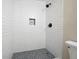 Modern shower features white subway tile, dark fixtures, niche, and stone floor at 705 Country Park Se Dr, Smyrna, GA 30080