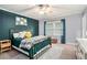 Cozy bedroom with a metal bed frame, teal accent wall, and bright natural light from the window at 2349 Henderson Mill Ne Rd # 2, Atlanta, GA 30345