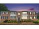 Charming brick townhouse with black shutters, trimmed windows and well-kept landscaping at dusk at 2349 Henderson Mill Ne Rd # 2, Atlanta, GA 30345