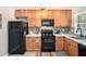 Charming kitchen featuring natural wood cabinets, black appliances, decorative backsplash, and bright countertop at 2349 Henderson Mill Ne Rd # 2, Atlanta, GA 30345
