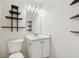 Bright bathroom featuring classic white fixtures, modern shelves, and a unique decorative mirror at 3055 Kennesaw Nw Dr, Kennesaw, GA 30152