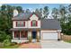 Charming two-story home with red shutters, covered porch, brick walkway, and attached two-car garage at 3055 Kennesaw Nw Dr, Kennesaw, GA 30152