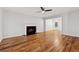 Spacious living room with hardwood floors, fireplace, ceiling fan, and an open view to the dining area at 3055 Kennesaw Nw Dr, Kennesaw, GA 30152