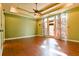 Bright bedroom featuring hardwood floors, tray ceiling, and access to the backyard at 3082 Monarch Pine Dr, Peachtree Corners, GA 30071