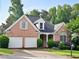 Charming brick home with a two-car garage and manicured landscaping at 3082 Monarch Pine Dr, Peachtree Corners, GA 30071