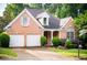 Charming brick home with a well-manicured lawn, mature trees, and a two-car garage at 3082 Monarch Pine Dr, Peachtree Corners, GA 30071