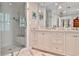 Elegant bathroom featuring a marble floor, double vanity, and frameless glass shower with white subway tile at 4476 Paces Battle Nw, Atlanta, GA 30327