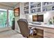 Well-lit home office with a built-in desk, shelving, and a door leading to outdoor deck at 4476 Paces Battle Nw, Atlanta, GA 30327