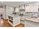 Bright kitchen with white cabinets, granite counters, and a center island with bookshelves at 4476 Paces Battle Nw, Atlanta, GA 30327