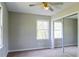 Bedroom with neutral walls, carpet, ceiling fan, and mirrored closet, bathed in natural light from two windows at 147 Harris Loop, Dallas, GA 30157