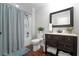Bathroom with a shower-tub combo, dark vanity, decorative mirror, and white towels at 18 Starlight Dr, Cartersville, GA 30121