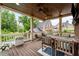 Inviting covered deck featuring wood ceiling, ceiling fan, and a wood table with seating overlooking backyard at 18 Starlight Dr, Cartersville, GA 30121