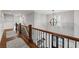 Spacious foyer with hardwood floors, wood railing, and an elegant chandelier at 18 Starlight Dr, Cartersville, GA 30121