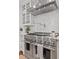 Modern kitchen with stainless steel range, a pot filler faucet, white marble backsplash, and custom cabinetry at 18 Starlight Dr, Cartersville, GA 30121
