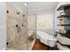 Spa bathroom featuring a soaking tub, tiled shower, modern fixtures, and decorative shelves at 18 Starlight Dr, Cartersville, GA 30121