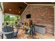 Outdoor patio featuring stone fireplace with chairs, brick wall, ceiling fan and tongue and groove ceiling at 18 Starlight Dr, Cartersville, GA 30121
