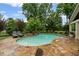 Backyard kidney shaped pool surrounded by stone, lush landscaping, and lounge chairs at 18 Starlight Dr, Cartersville, GA 30121