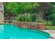 Close-up view of a backyard swimming pool with a stone waterfall feature and adjacent lounge chairs at 18 Starlight Dr, Cartersville, GA 30121