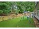 The fenced backyard features a swing set and mature trees at 1162 Apalachee Run Trl, Dacula, GA 30019