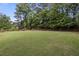 Lush backyard featuring mature trees and ample space, perfect for outdoor activities at 1253 Willow Dr, Riverdale, GA 30296