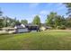 Expansive backyard view showcasing the house exterior, carport, and surrounding greenery at 1253 Willow Dr, Riverdale, GA 30296
