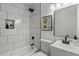 Bright bathroom with marble-look tile, tub, and updated fixtures at 1253 Willow Dr, Riverdale, GA 30296