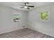 Bright bedroom featuring a ceiling fan, two windows and wood-look laminate flooring at 1253 Willow Dr, Riverdale, GA 30296