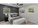 Charming bedroom with a panel accent wall, two windows, and neutral decor at 1253 Willow Dr, Riverdale, GA 30296
