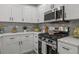 Charming kitchen featuring white cabinets, quartz countertops, stainless steel appliances, and stylish backsplash at 1253 Willow Dr, Riverdale, GA 30296