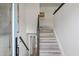 Inviting staircase with light wood steps and a dark wood handrail at 1253 Willow Dr, Riverdale, GA 30296