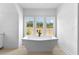 Modern bathroom featuring a freestanding tub and large windows offering great views at 206 Regester Way, Peachtree City, GA 30269