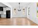 Bright dining room featuring hardwood floors, white trim, large windows, and a stylish chandelier above the dining area at 206 Regester Way, Peachtree City, GA 30269