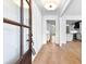 Elegant foyer with hardwood floors, white walls, a decorative light fixture, and a view into the modern kitchen at 206 Regester Way, Peachtree City, GA 30269