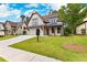 Charming two-story home with a manicured lawn, dark trim, and attached two car garage at 206 Regester Way, Peachtree City, GA 30269