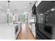 Open-concept kitchen featuring a large island, white cabinets, black appliances, and a view to the living area at 206 Regester Way, Peachtree City, GA 30269