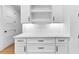 Kitchenette area features white cabinets, bronze hardware, and herringbone backsplash tiles at 206 Regester Way, Peachtree City, GA 30269