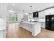 Modern kitchen featuring white cabinets, a large island with a white countertop, and black appliances throughout at 206 Regester Way, Peachtree City, GA 30269