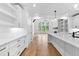 Bright kitchen with white cabinets, a large island, hardwood floors, and a view into the living room at 206 Regester Way, Peachtree City, GA 30269