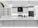 Beautiful kitchen island with white cabinets, marble countertops, white backsplash, and built in shelving at 206 Regester Way, Peachtree City, GA 30269
