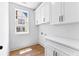 Well-lit laundry room with white cabinets, counter space, and a window for natural light at 206 Regester Way, Peachtree City, GA 30269
