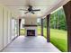 Inviting outdoor patio with a stone fireplace, ceiling fan, and lush backyard view at 206 Regester Way, Peachtree City, GA 30269