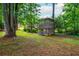 A backyard with a unique two-story structure surrounded by lush trees and greenery at 3549 Dogwood Dr, Powder Springs, GA 30127