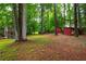 Large backyard with mature trees, grass, and a detached additional structure at 3549 Dogwood Dr, Powder Springs, GA 30127