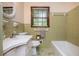 Modest bathroom featuring classic tile work, window, and standard fixtures at 3549 Dogwood Dr, Powder Springs, GA 30127