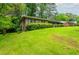 A charming single-story brick house on a green, gently sloping lawn, surrounded by lush trees at 3549 Dogwood Dr, Powder Springs, GA 30127