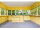 Yellow sunroom featuring many windows and a neutral gray floor at 3549 Dogwood Dr, Powder Springs, GA 30127