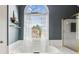 Well-lit bathroom featuring a large soaking tub with a big arched window and shower at 840 Yosemite Dr, Suwanee, GA 30024