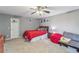 Comfortable carpeted bedroom with ceiling fan, red comforter, and natural light at 840 Yosemite Dr, Suwanee, GA 30024